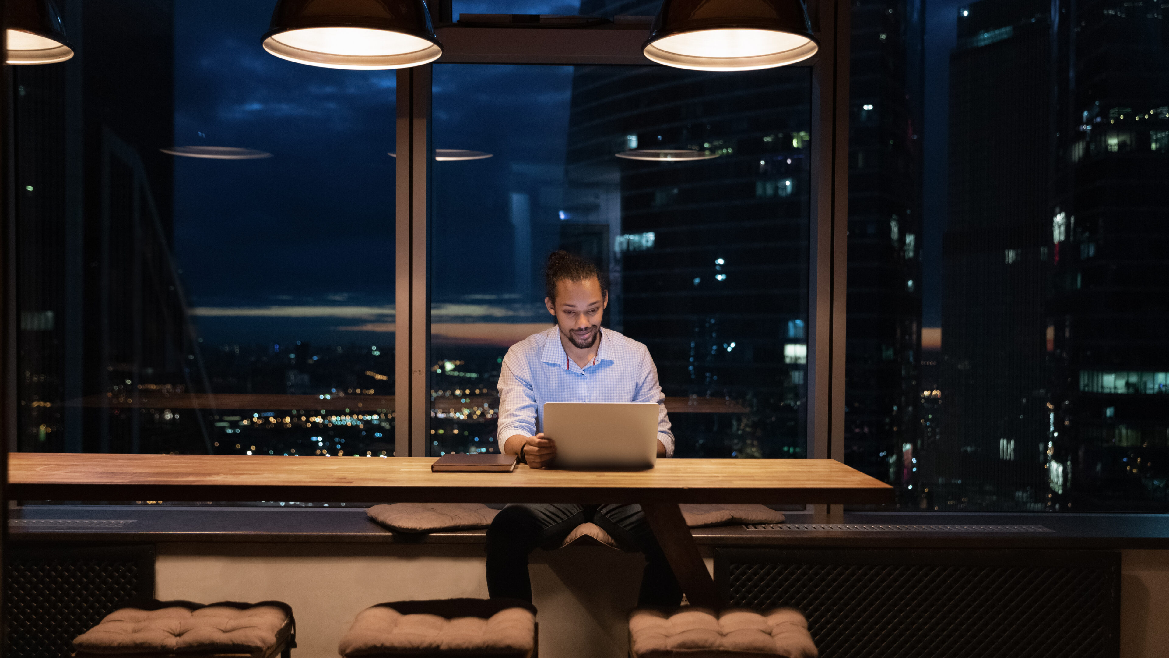 African American businessman working on laptop in office at night